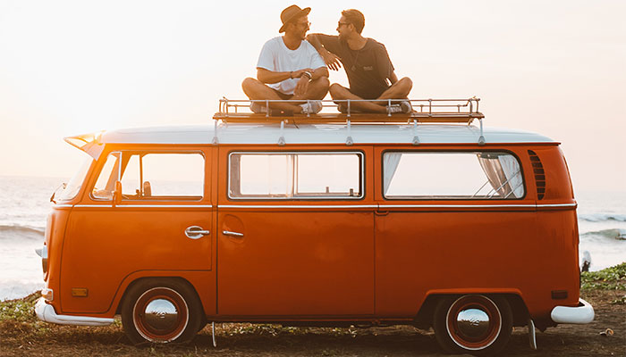 Two friends sitting on orange VW bus after buying Delta 8 gummies in Ballard County, Kentucky from Simple Garden CBD.