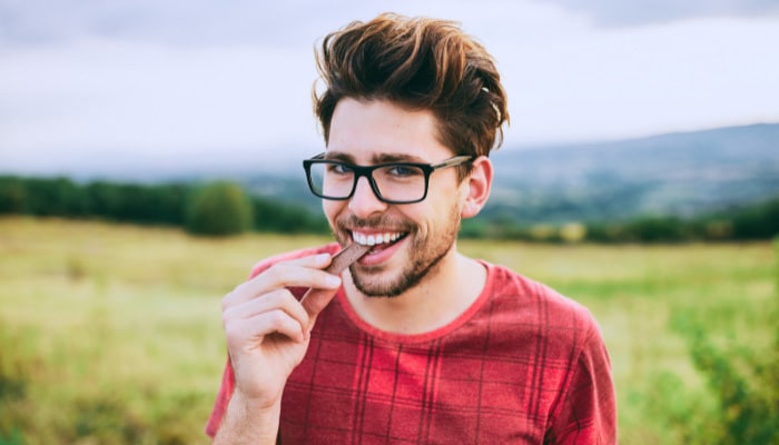 Man eating St. Paul Delta 8 THC Chocolate Edibles bought from Simple Garden.