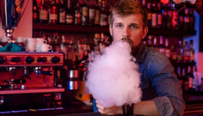 Man in bar using THC Disposable Vape near Garland.